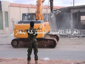 A soldier stands by as workers from the BJSR destroy illegal buildings (Photo: BJSR)